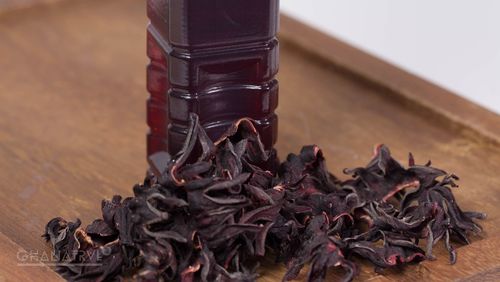 Local Dishes - Sobolo - spicy refreshing hibiscus drink Local Dishes - A bottle of crimson Sobolo with hibiscus flowers